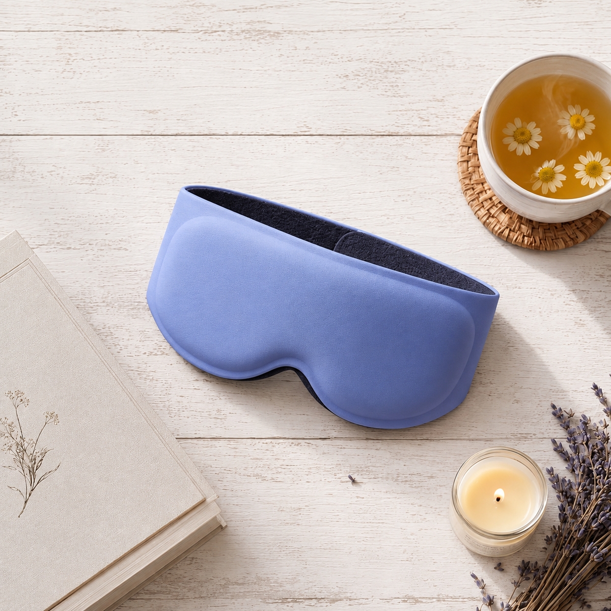 Blue contoured weighted sleep mask beside a cup of tea